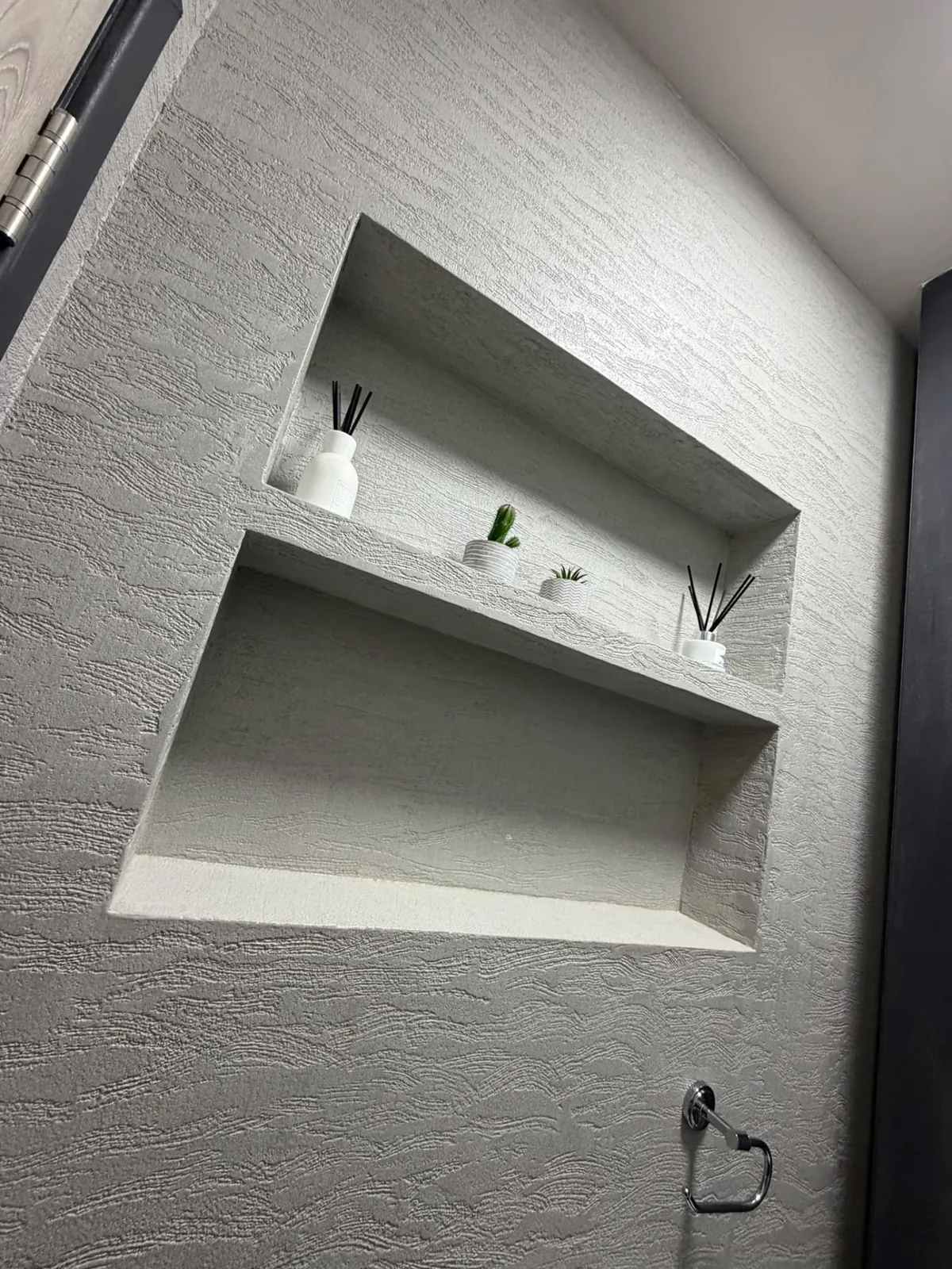 Microcement wall with recessed shelving finished as one continuous surface