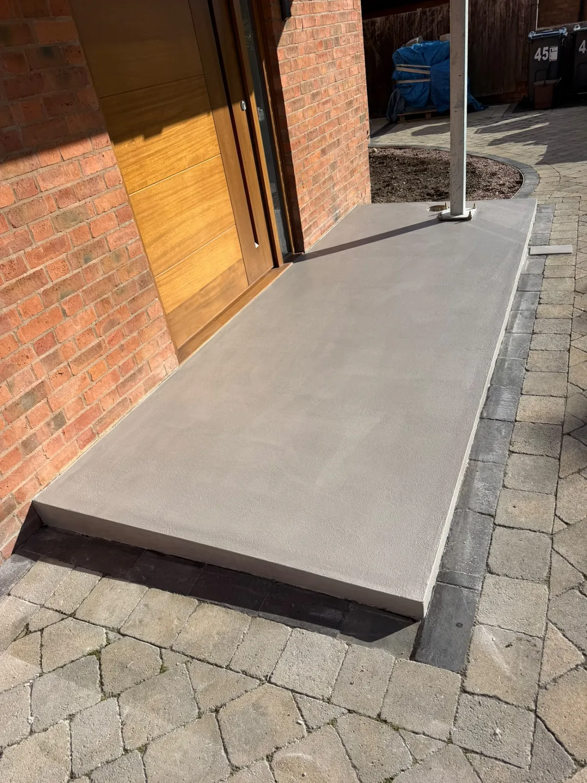 Microcement entrance surface laid seamlessly across an exterior slab