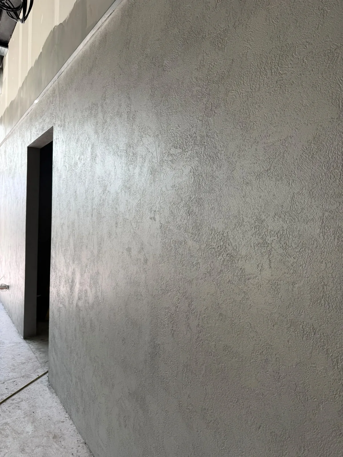 Large textured microcement wall running the full height of a room
