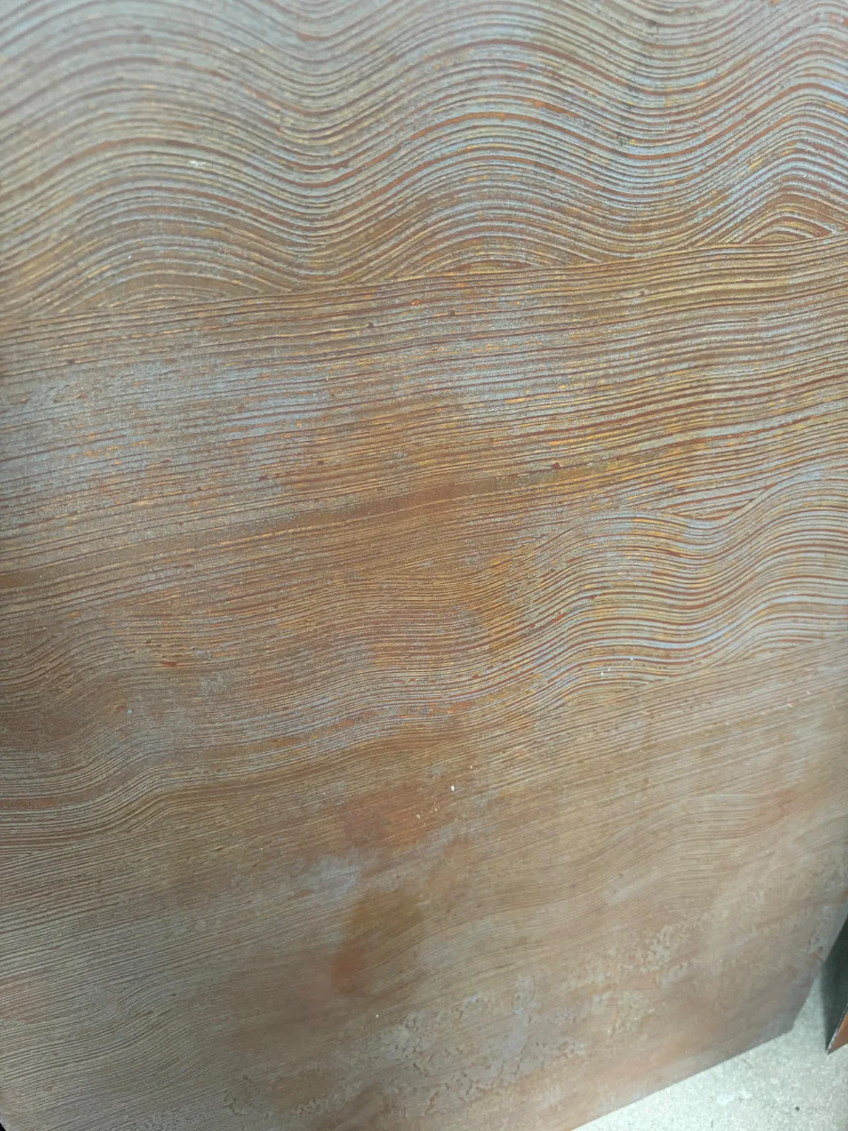 Close-up of a bronze liquid metal decorative finish with a wave texture