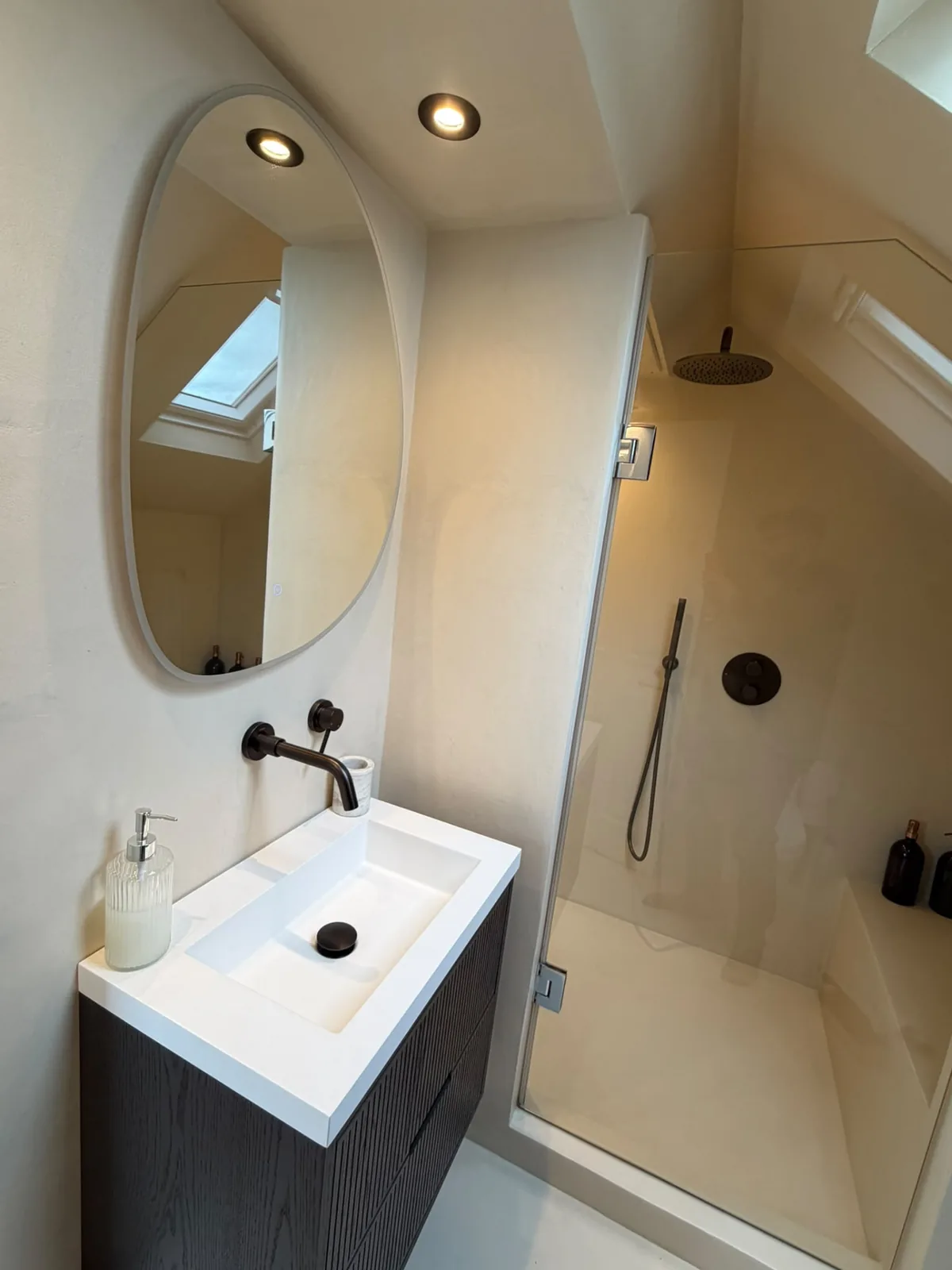 Loft bathroom with microcement shower walls and a fitted vanity