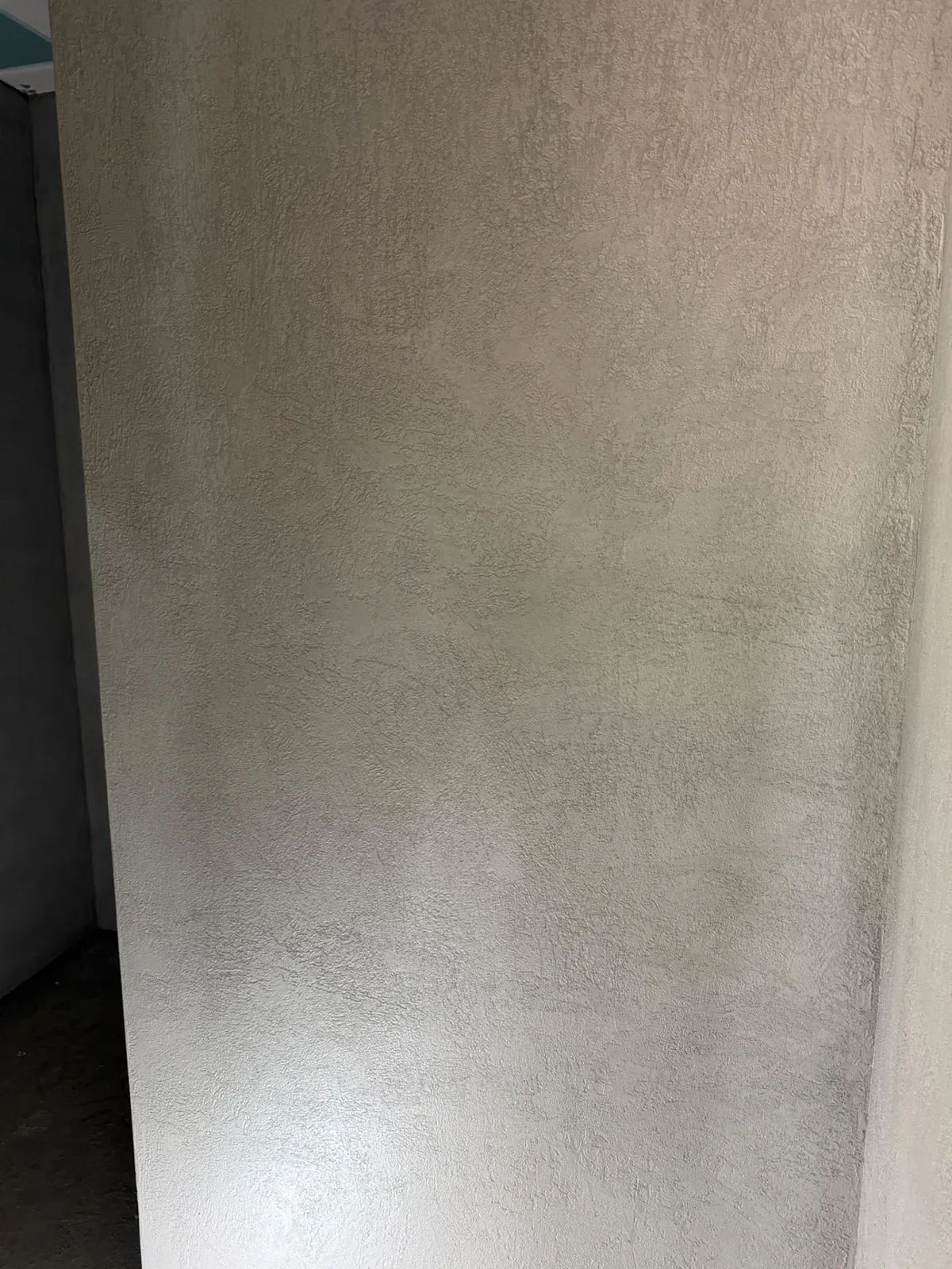 Detail of a grey microcement wall finish showing subtle tonal variation