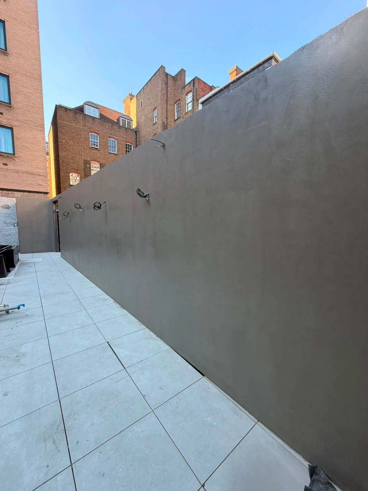 External microcement courtyard walls finished in warm grey