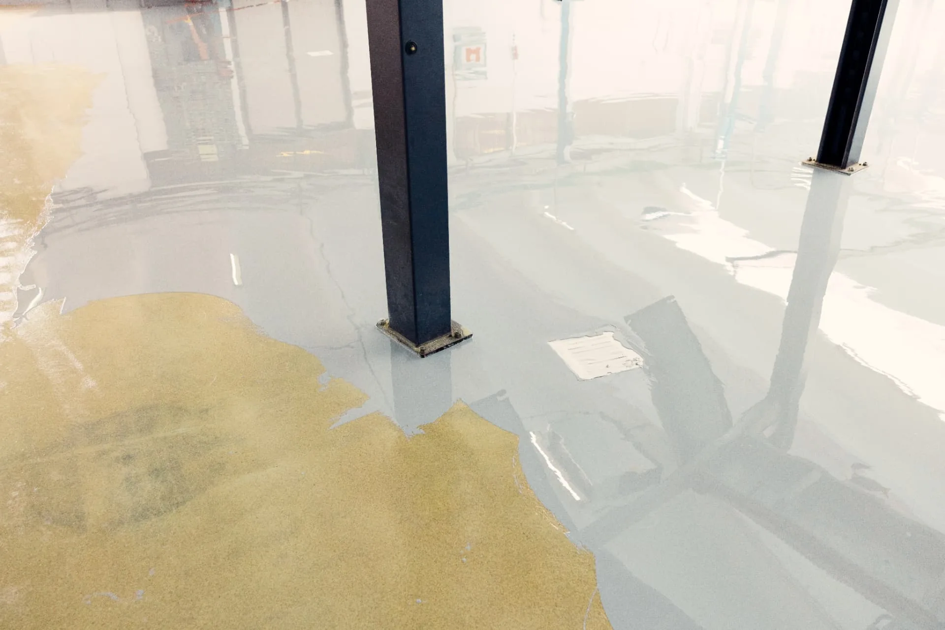 Poured resin flooring levelling out to a high-gloss seamless finish