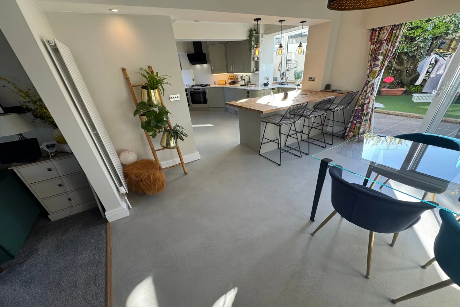 Open-plan kitchen and dining room with a seamless grey microcement floor