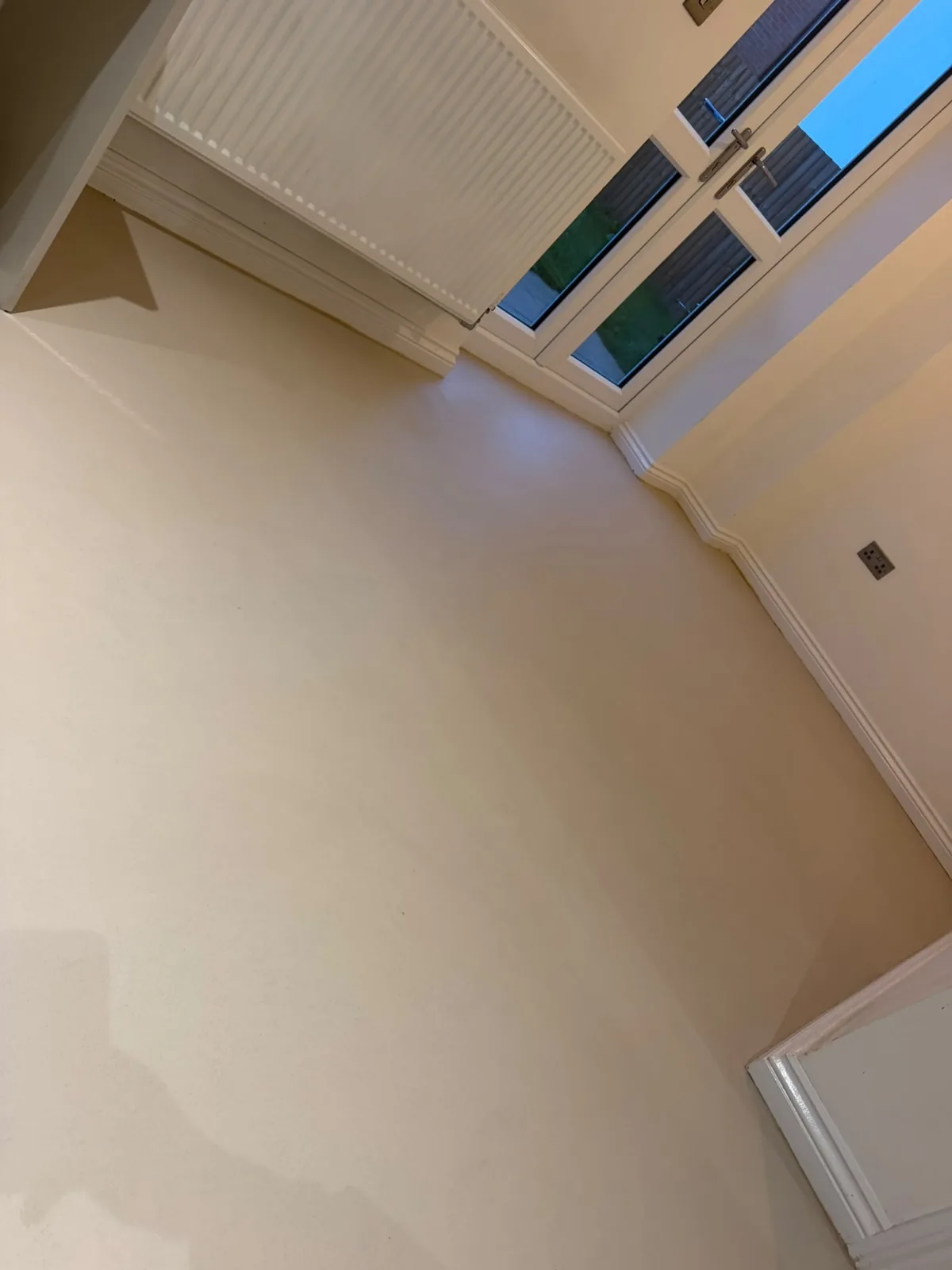 Cream microcement floor running seamlessly up to an internal doorway