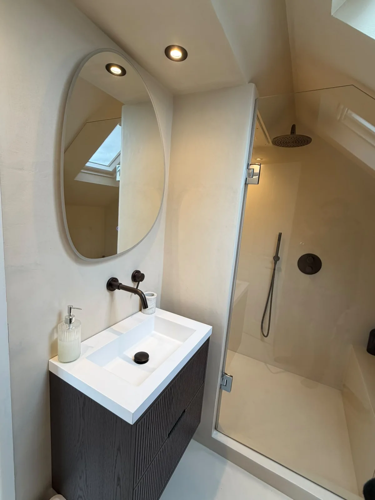 Loft bathroom finished in microcement with a shower and vanity unit