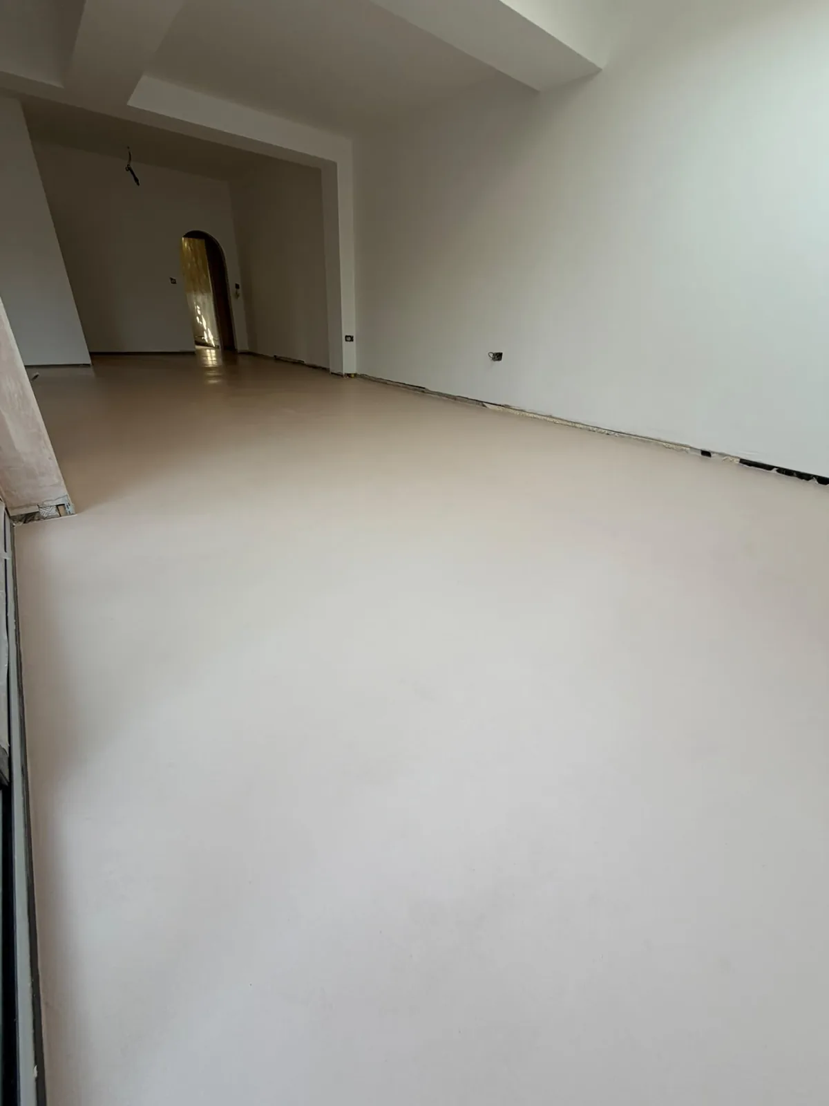 Open-plan room with a seamless cream microcement floor
