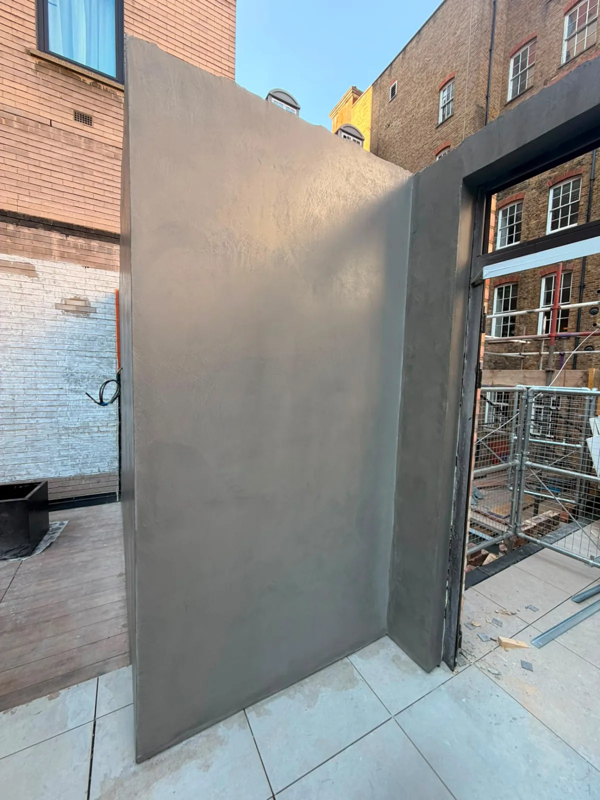 Exterior microcement partition wall finished seamlessly on both faces