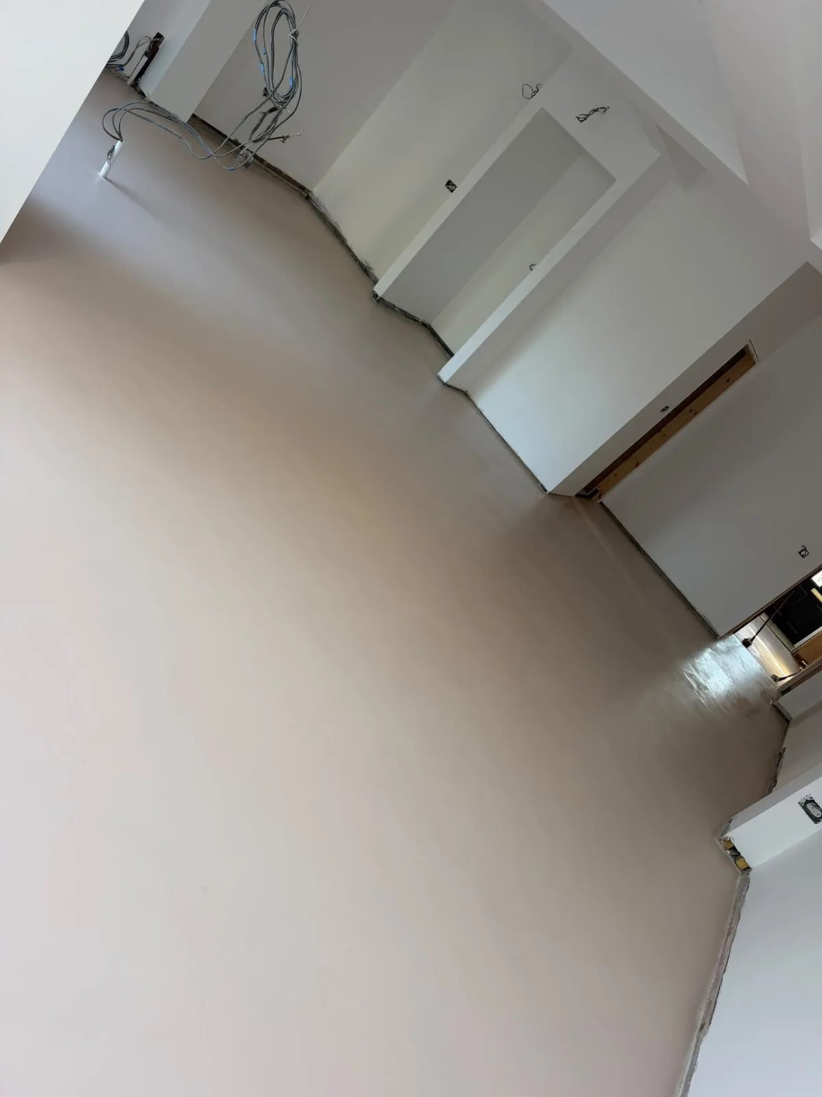 Warm-toned seamless microcement floor in a large living space