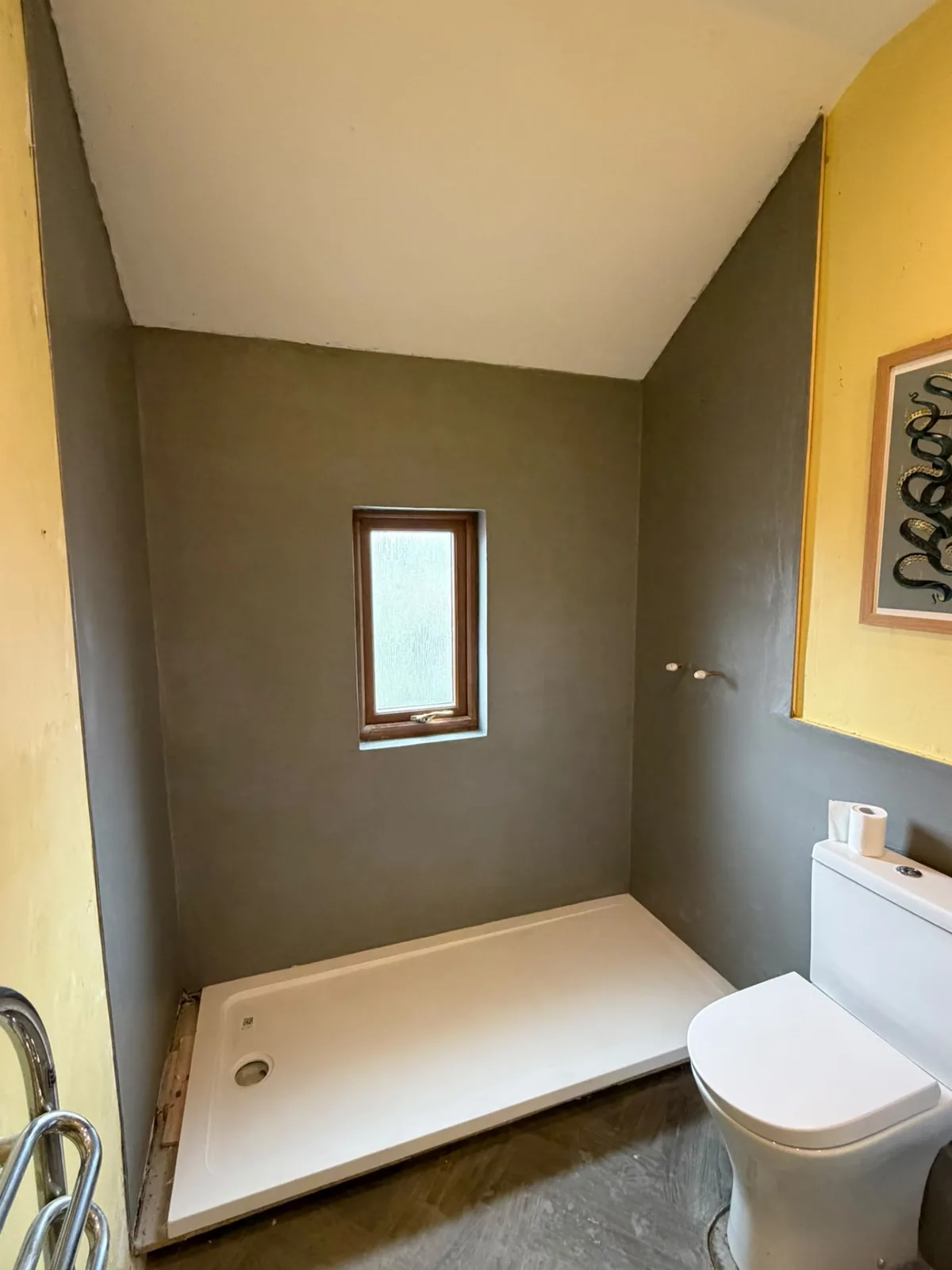 Grey microcement shower walls above a seamless shower tray